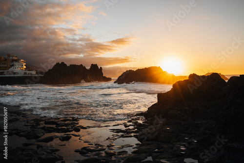 Sunset over the Atlantic Ocean with Mount Teide in the background, Tenerife, Canary Islands, Spain. Beautiful golden light illuminating the sky and sea, capturing the island’s volcanic landscape