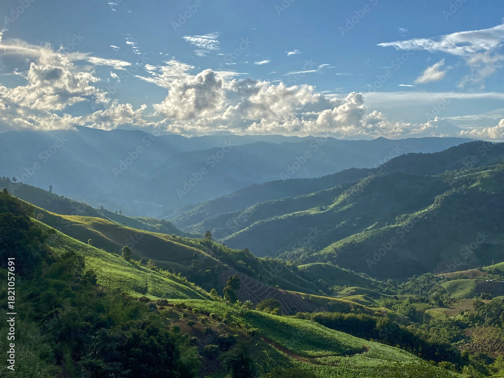 Fototapeta premium Layers of green mountains, sun rays, cloudscape, landscape meadows.