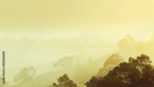 Wallpaper Mural Ethereal golden mist gently embraces forested hills and valleys, bathed in the soft glow of dawn or dusk. Torontodigital.ca