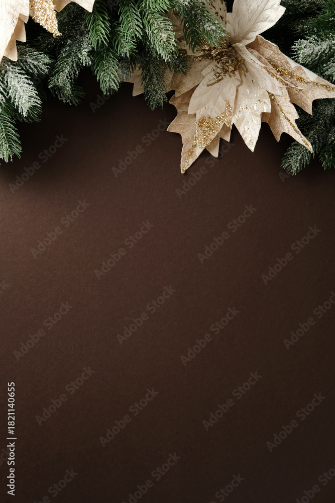 Fototapeta premium Vertical elegant Christmas background with frosted pine and gold glitter poinsettia along the top edge