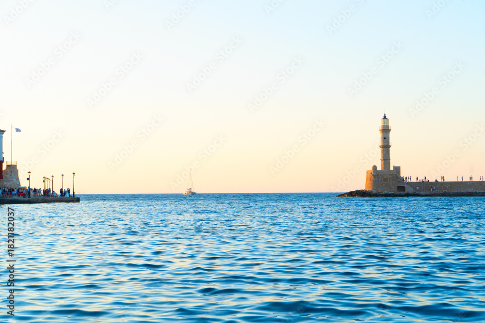 Fototapeta premium bay of Chania with sea and lighthouse at sunny summer sunset, Crete, Greece, web banner format