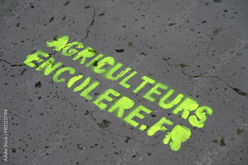 pochoir des agriculteurs en colère en lettres jaunes fluorescentes sur un fond gris