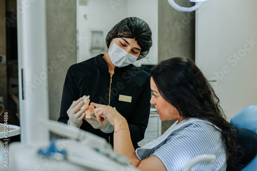 Canvas-taulu Dentist guiding a patient through treatment concepts using a dental model