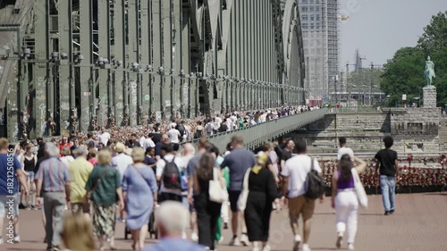 Wallpaper Mural Crowd of unrecognizable blurred people walking on Hohenzollern bridge over Rhine river in Cologne, Germany in slow motion, selective focus cinematic shot Torontodigital.ca