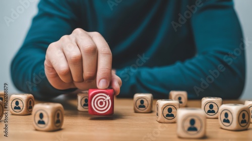 Target Focus: A hand strategically selects a target block amidst a field of character blocks, symbolizing precise goal-setting and strategic alignment. Capturing the essence of focus and precision.