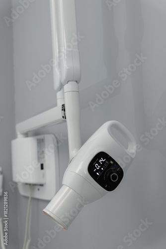 Wall mounted dental X ray tube with control panel, closeup.