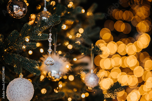 Festive decoration scene, Elegant holiday ornament setup, Bright glass ornament with festive lighting ambiance, Decorative glass piece hanging on pine branch with glowing lights