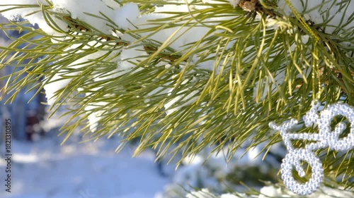 Christmas tree with decorations, back yard. Snowing. Snow covered trees in a winter landscape. Cold weather. Beauty in nature