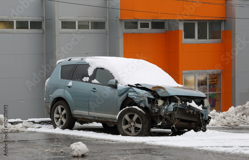 A snow-covered, broken light blue car is abandoned on the street, Podvoyskogo Street, Saint Petersburg, Russia, November 25, 2025