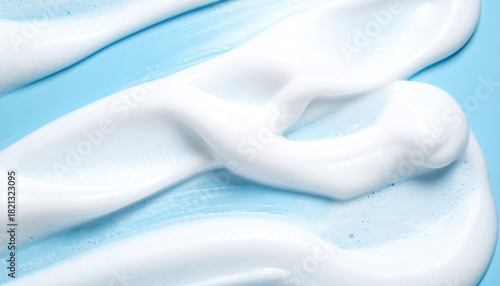 Creamy white foam swirls on a light blue background