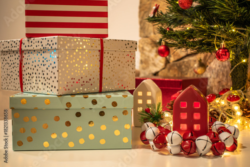 Christmas decorations: gifts wrapped in paper, candle, Christmas baubles and ornaments, and a garland glowing with warm light.