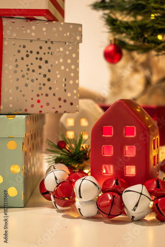 Christmas decorations: gifts wrapped in paper, candle, Christmas baubles and ornaments, and a garland glowing with warm light.