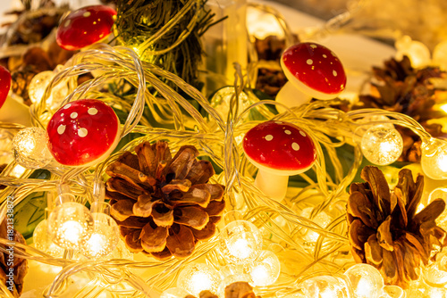 Christmas decoration and decor. A glowing garland with warm light, pinecones, and mushroom-shaped ornaments.