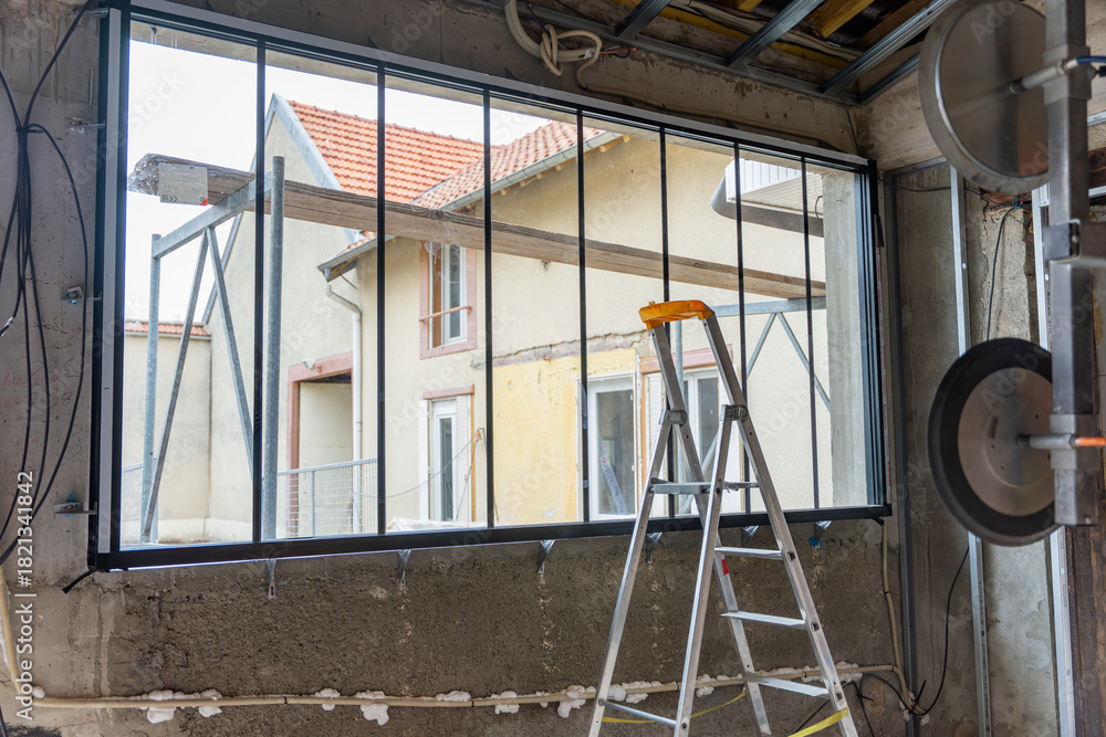 Φωτογραφία Gros plan sur une grande verrière installée dans un bâtiment en travaux, révélant la structure métallique, le vitrage et l’avancement du chantier