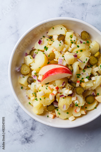 Traditional German potato salad with pickles, onions and apple.