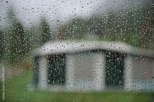 Looking outside the camper at a tent at the camping while it is raining