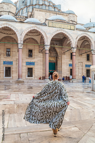 Woman in a traditional oriental robe in the courtyard of the Suleymaniye Mosque.