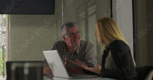 Colleagues smile and clasp hands in moment of friendly support during office meeting, celebrating teamwork and shared success