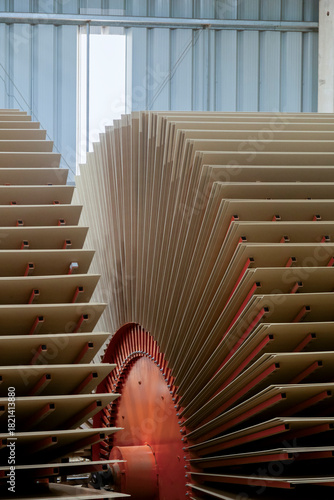 Large stacks of wood panels or MDF sheets arranged inside an industrial production facility. The image shows part of the machinery used to process and dry wood panels.