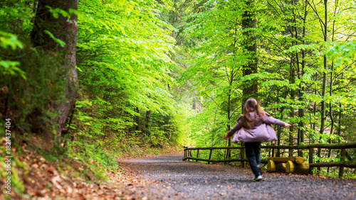 Wallpaper Mural Young girl running on a dirt road in a green forest Torontodigital.ca