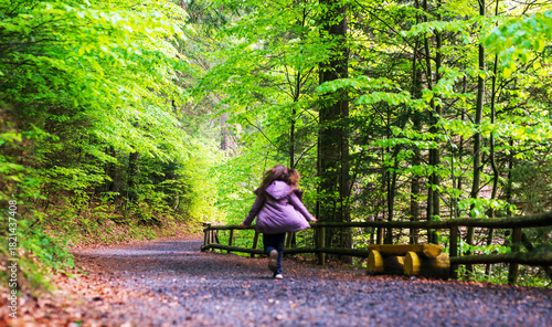 Wallpaper Mural Young girl running on a dirt road in a green forest Torontodigital.ca