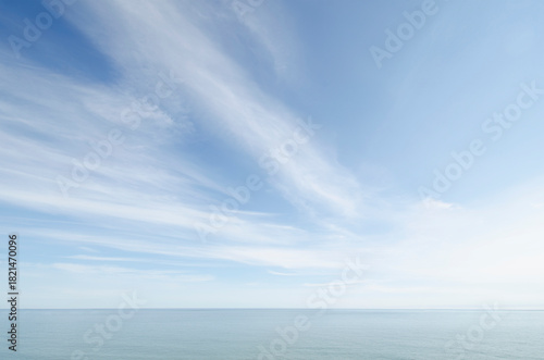 White wispy clouds above calm sea
