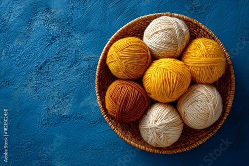 Yarn Balls in Warm Colors Arranged in a Woven Basket on a Blue Background