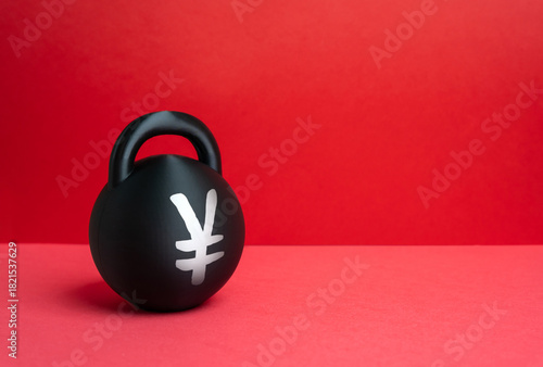 Fototapeta Naklejka Na Ścianę i Meble -  A weight with the Yen or Yuan symbol. Conceptually, it represents the burden of debt and economic problems. Financial stress and economic risk. Investment, banking and macroeconomic reports.