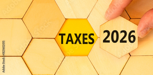 Taxes 2026 new year symbol. Concept words Taxes 2026 on beautiful wooden puzzles. Beautiful wooden puzzles background. Businessman's hand. Business and taxes 2026 new year concept. Copy space.