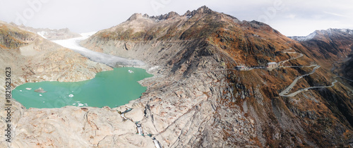 The melting Rhône Glacier feeds a large turquoise lake beside the winding Furka Pass road and iconic Hotel Belvédère.