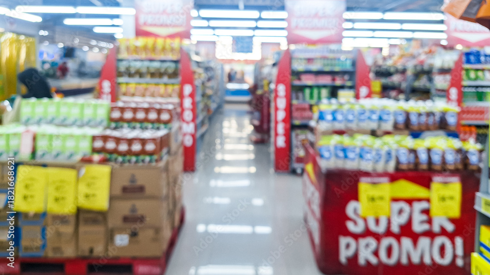 Fototapeta premium Blurred background of interior of supermarket store aisle with various products on shelves and a prominent 