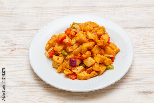 Pommes de terre en cubes assaisonnées de sel et poivre sur assiette blanche. Cuisine chinoise. Traiteur.