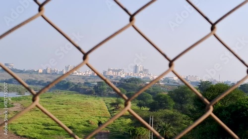 A peaceful riverside landscape featuring lush green fields, flowing water, and a clear blue sky. The natural scenery creates a calm and refreshing atmosphere.