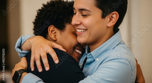 Diverse people hugging and smiling indoors
Close-up of two diverse young people warmly embracing each other with joyful expressions. One has short dark hair, the other has curly afro hair. Concept of 