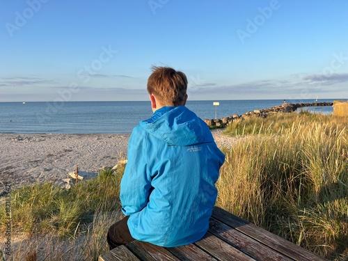 boy sitting and looking over the sea
