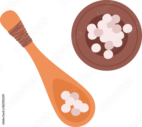 A spoon and a bowl of small white balls