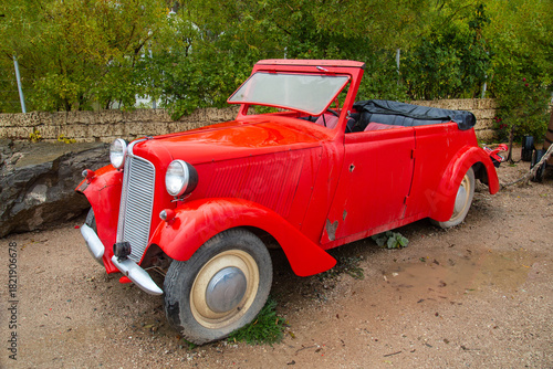 Vintage convertible passenger car in red on a clear sunny day. Transportation recreation sports hobbies travel