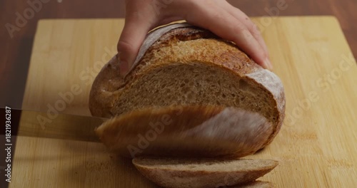 Slicing Wholegrain Bread Cri On Slice For Bruschetta. Cutting Sourdough Bread On Kitchen. Making Morning Toast Breakfast.Fresh Crisp Sourdough Bread On Table. Cutting French Multigrain Bread For Toast