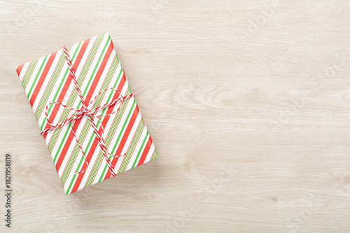 Striped Christmas gift boxes on wooden background, top view