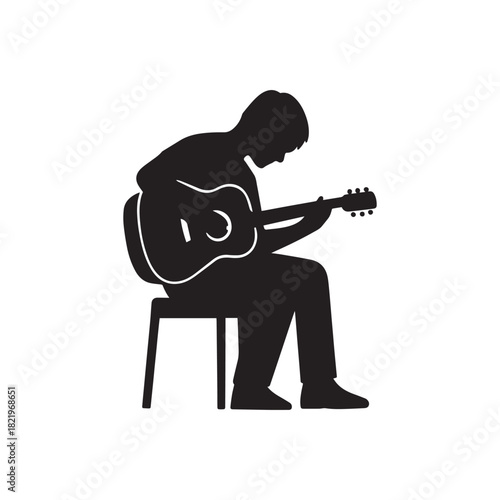 Silhouette of a person sitting on a stool playing an acoustic guitar