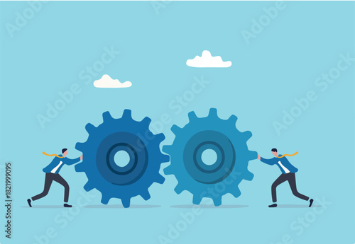 Teamwork and cooperation in a business setting, idea that working together can lead to success, collaboration or synergy concept, businessman push gear cogwheels together leading to success. 