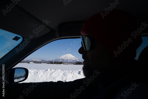 Man driving overlooking mount Yotei in Hokkaido