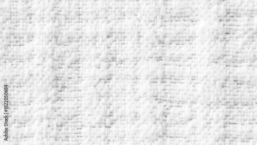 Background from white coarse canvas texture. Textured white knit fabric showcases intricate weaving patterns and soft fibers suitable for cozy apparel and home textiles.
