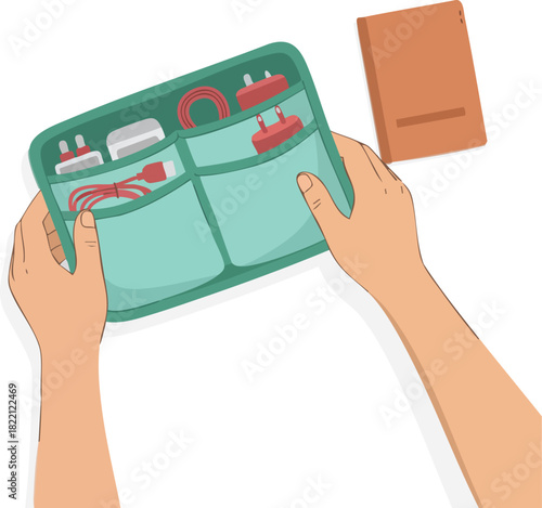 Hands organizing a small tech pouch filled with chargers, cables, and electronic accessories placed beside a closed notebook on a clean surface