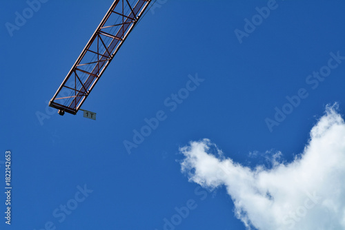 Una gru in un cantiere edile con il cielo blu sullo sfondo.
