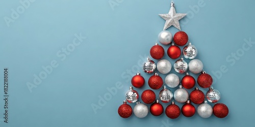 Christmas tree shape made of red and silver ornaments on blue background