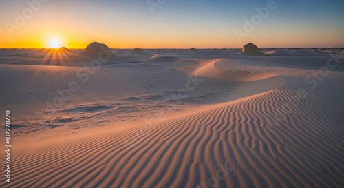 Fototapeta Naklejka Na Ścianę i Meble -  Golden hour sunset over a serene white desert landscape with rippled sand dunes