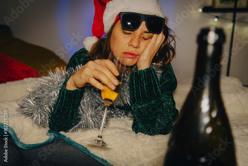 Bored woman with a glass of champagne Tired of Christmas and New Year's holidays