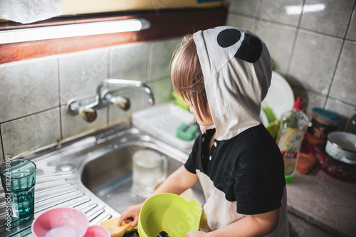 A little girl washing dishes