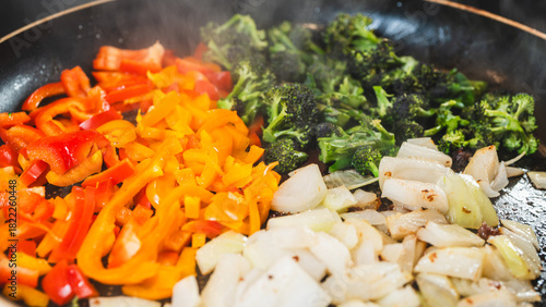 Fotografie Colorful mix of onions, broccoli, and bell peppers sizzling in a pan